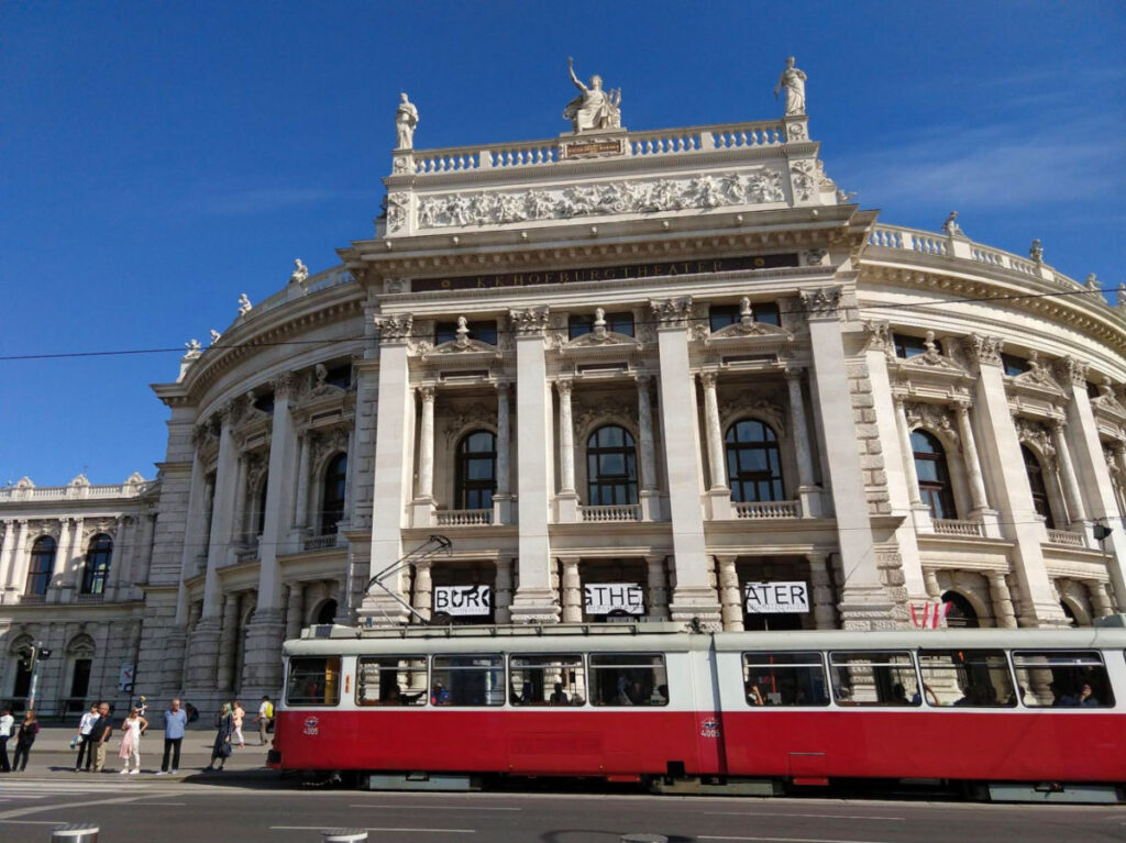 Red and white tram in front of Burgtheater
