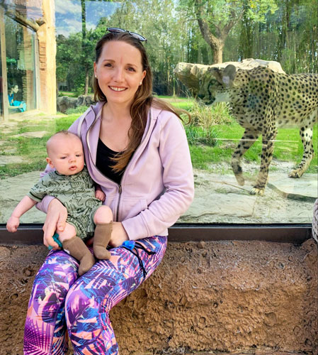 View of the author holding a baby and a cheetah on their background