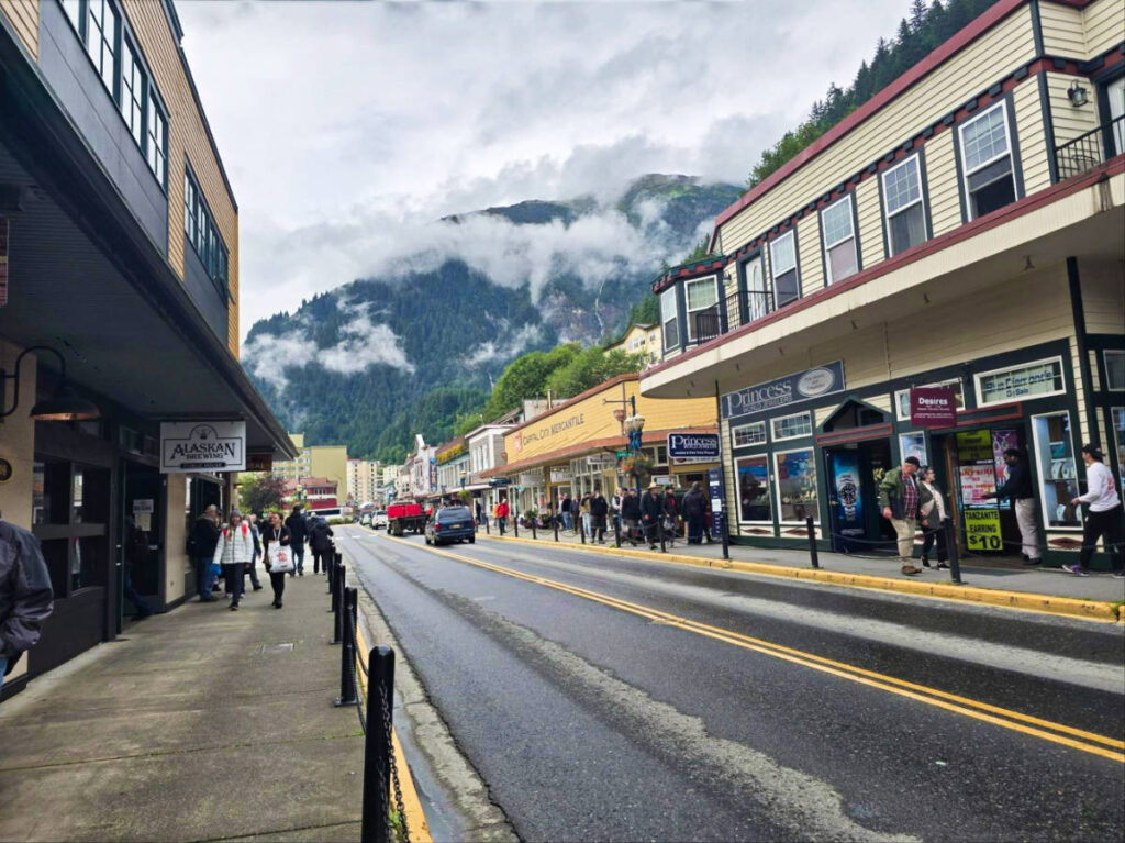 View of the people along Downtown Juneau with foggy mountain views behind