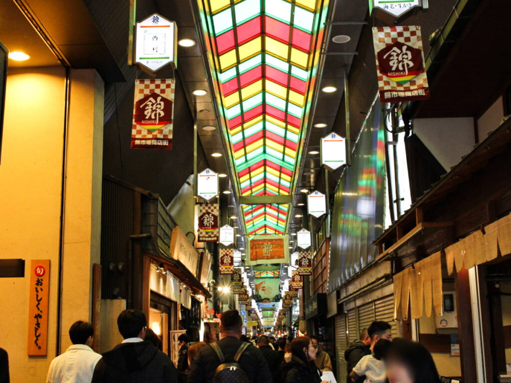 View of the crowd and the colorful ceiling in Nishiki Market