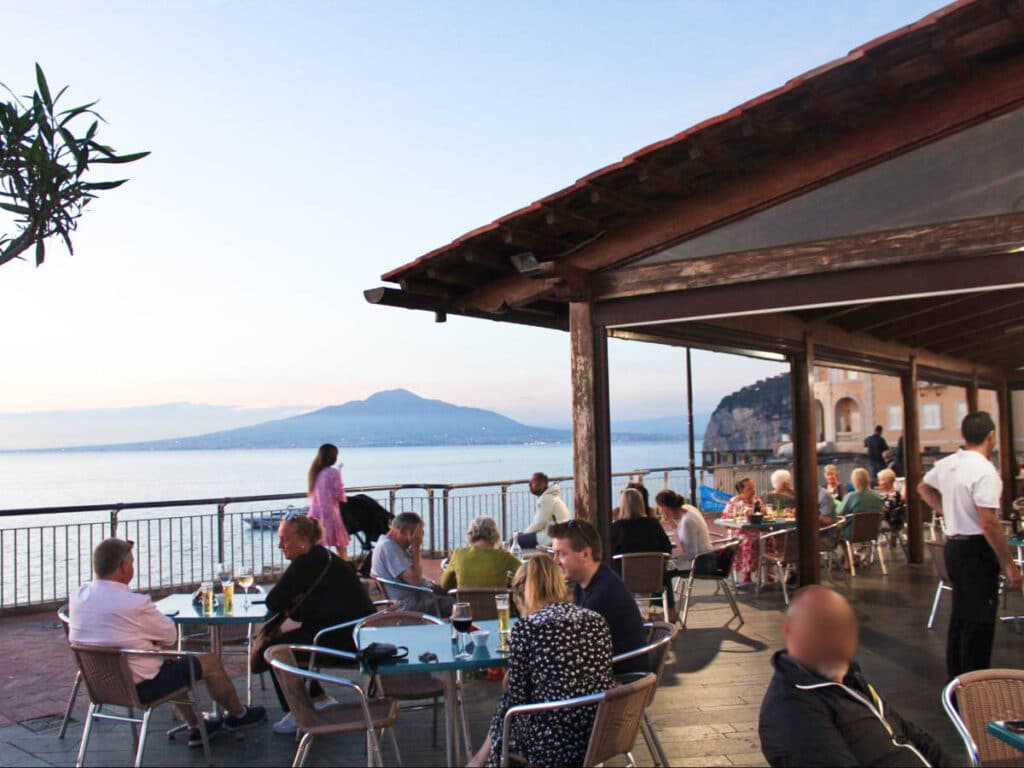 View of the crowd dining in a restaurant in Sant'Angelo with an overlooking view in the background