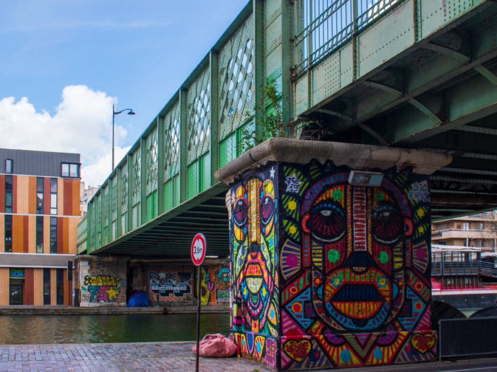 A segment of a bridge in Buttes-Chaumont painted with a colorful art
