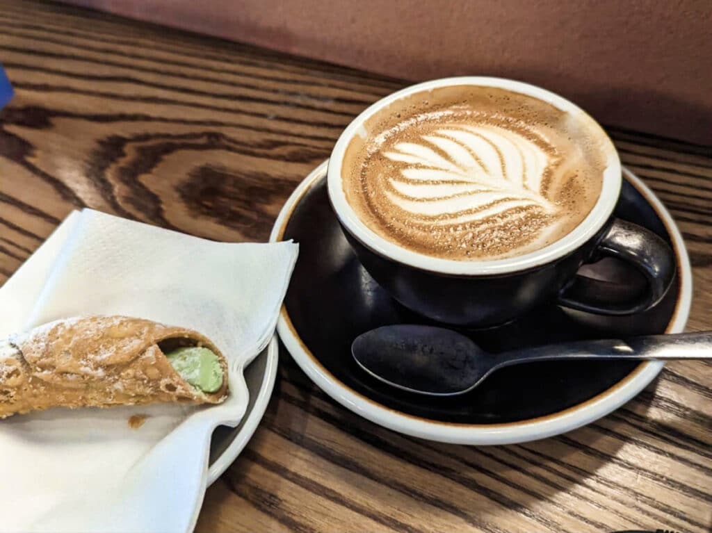 A cup of coffee and a pasty from a coffee shop
