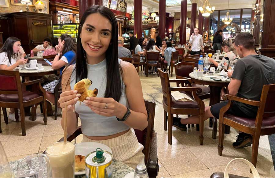 Clara holding a pastry served in Café Tortoni