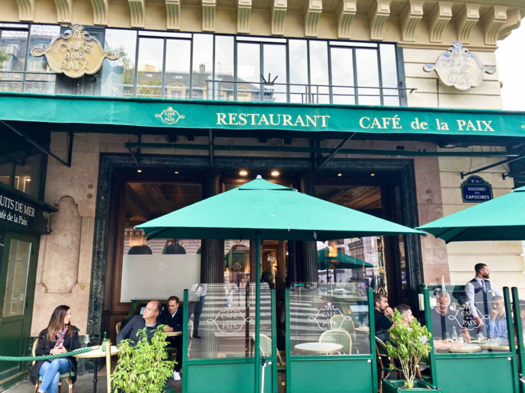 People chilling at the vibrant exterior and terrace of Café de la Paix