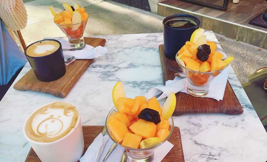 View of fruits and lattes on a table from a cafe in Escandon