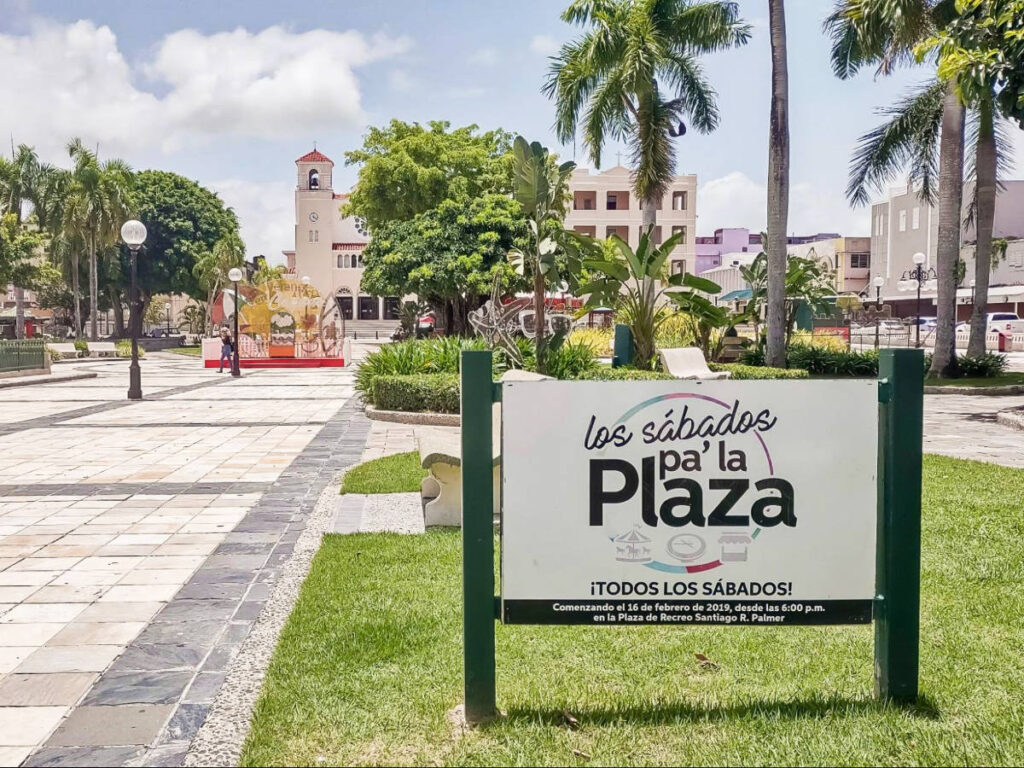 A signage at the Caguas main town square surrounded by historic architecture and lush greenery
