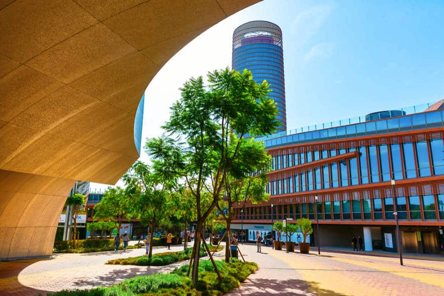 View of the skyscraper Torre Sevilla from the open area with people strolling around