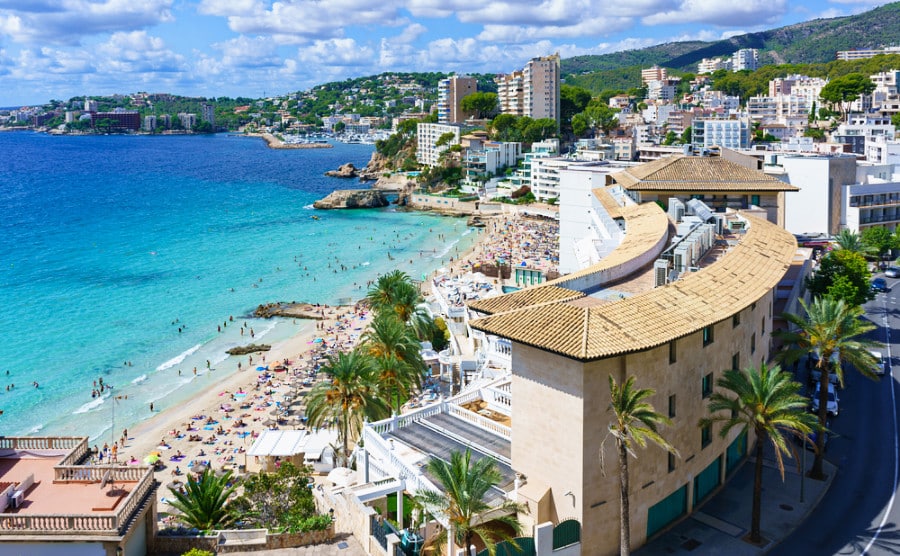 Aerial view of the skyline and busy beach of Cala Major Beach in Palma de Mallorca