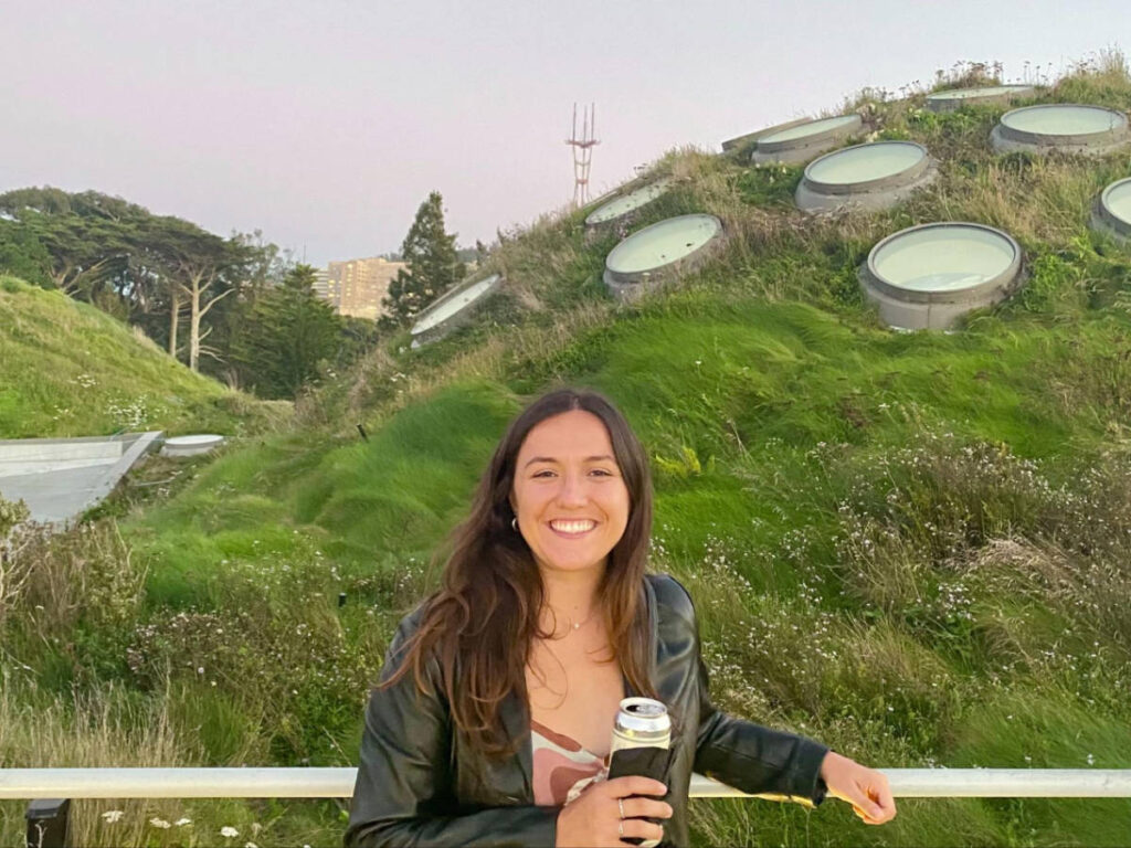 The author's partner smiling for a photo while holding her drink in California Academy of Sciences NightLife