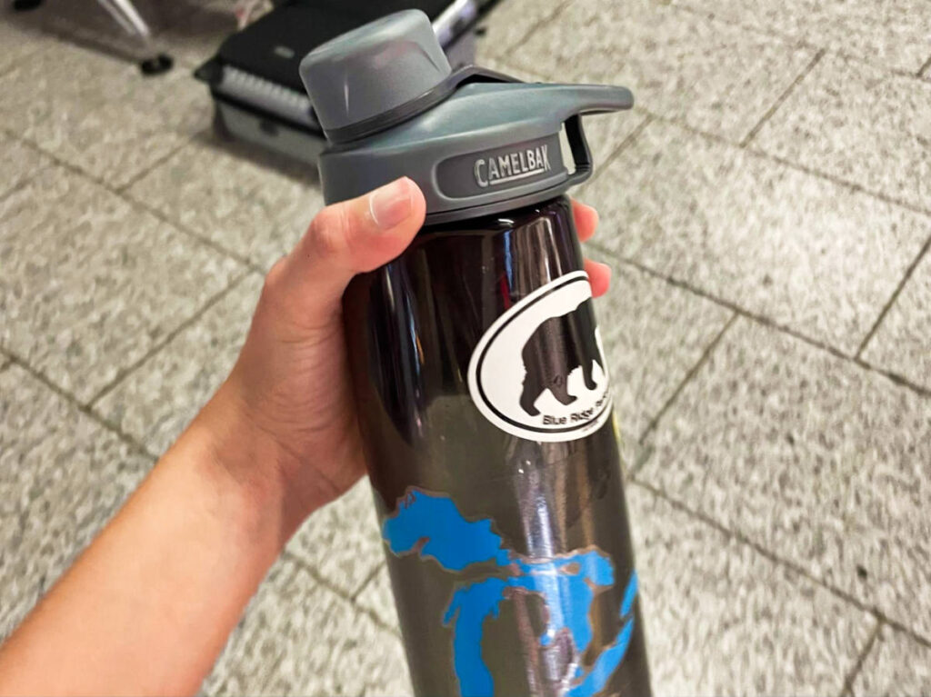 A hand holding the Camelbak water bottle