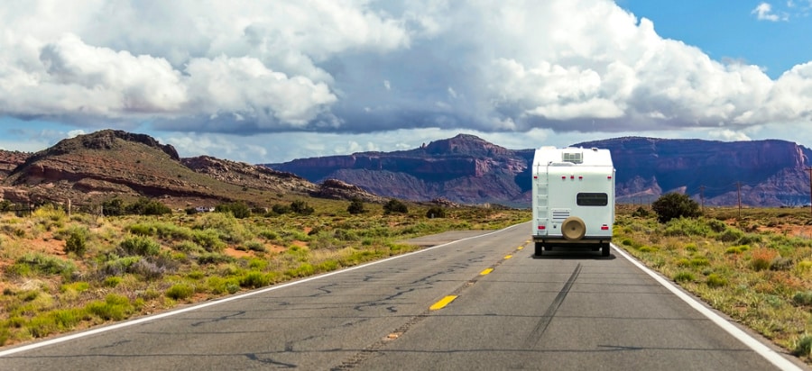 A camper trailer on the highway with scenic views