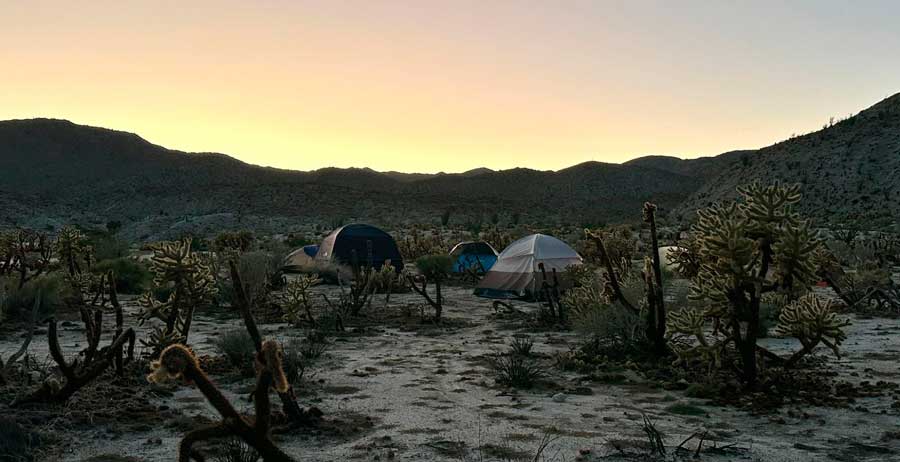 Camping tents under the colorful sky during sunset in Anza Borrego