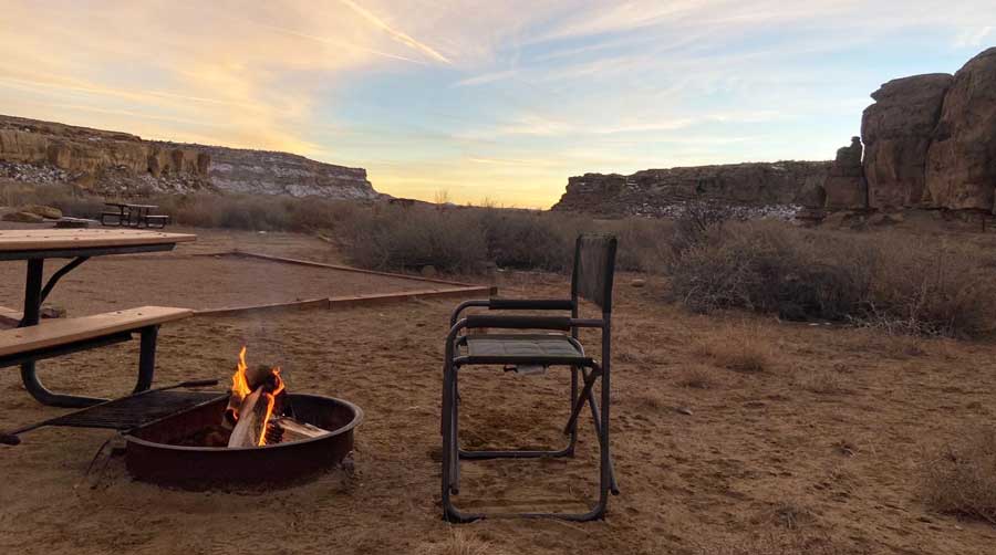 A camp chair near a camp fire