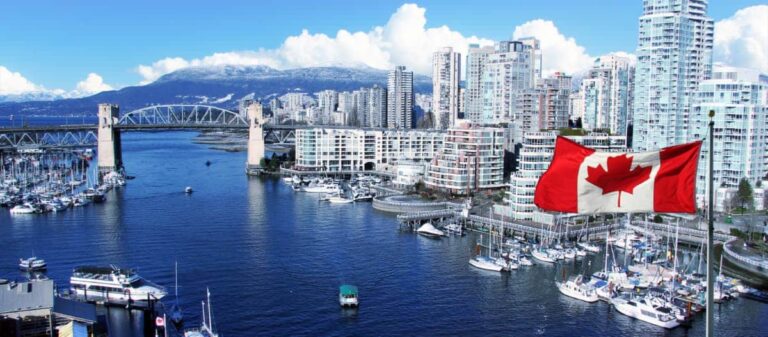The Canadian flag proudly waves above the skyline of Vancouver