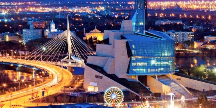 The Canadian Museum of Human Rights at night, with Winnipeg lit up behind it