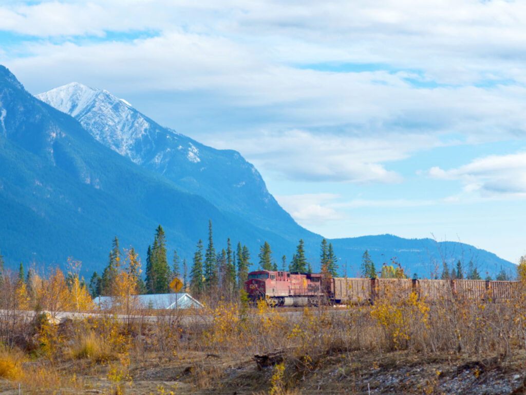 Train passing by the town of Golden, with the Canadian Rockies in the background