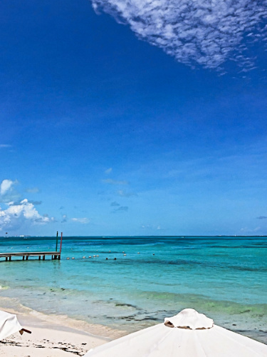 View of the boardwalk, white sand and turquoise blue water of Cancun
