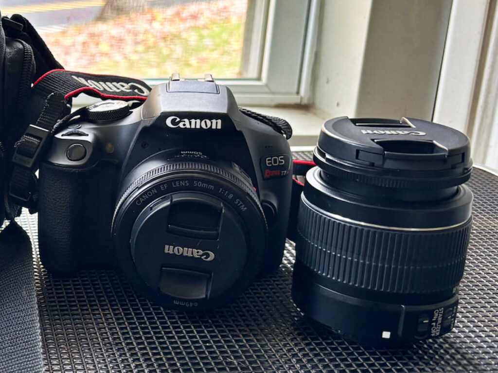 The Canon EOS Rebel T7 DSLR Camera and the Canon lens on the table