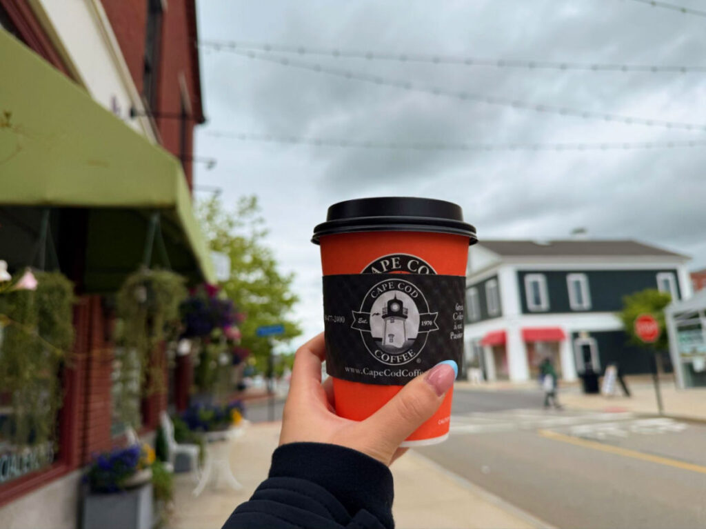 Holding up a cup of Cape Cod Coffee from Mashpee Commons