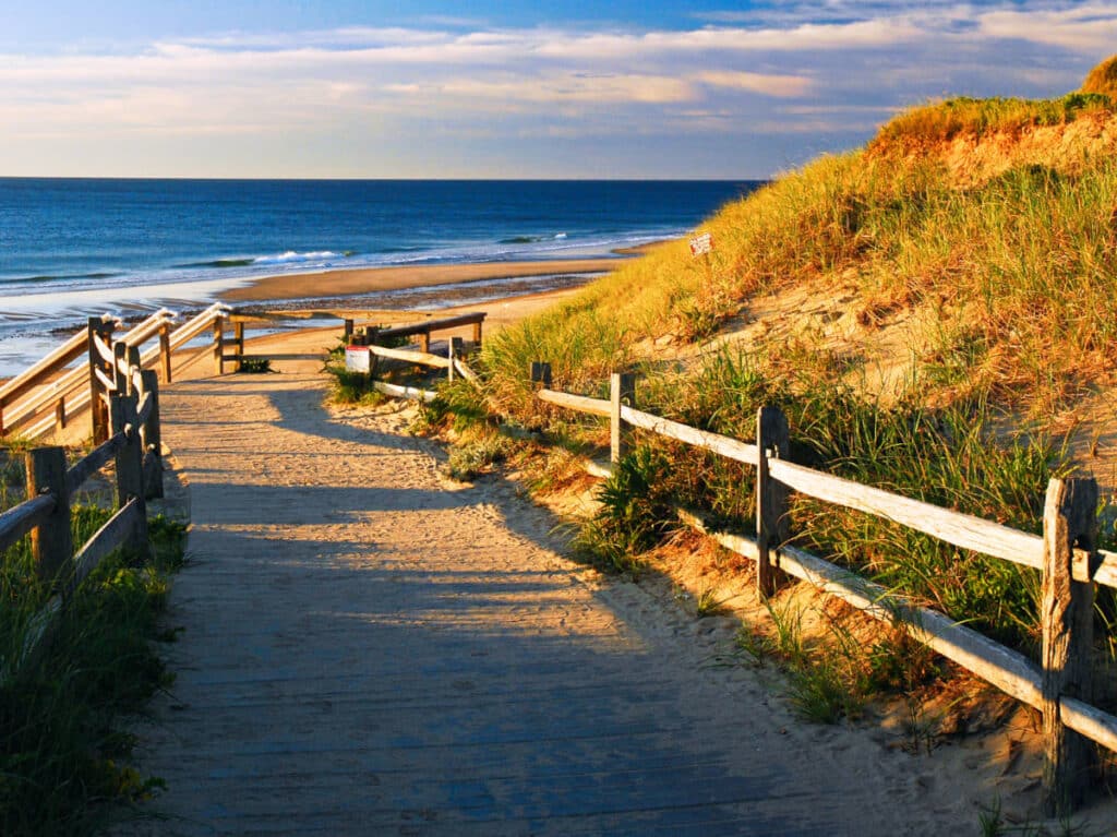 View of golden sunset over the pathway leading to the water in Cape Cod National Seashore