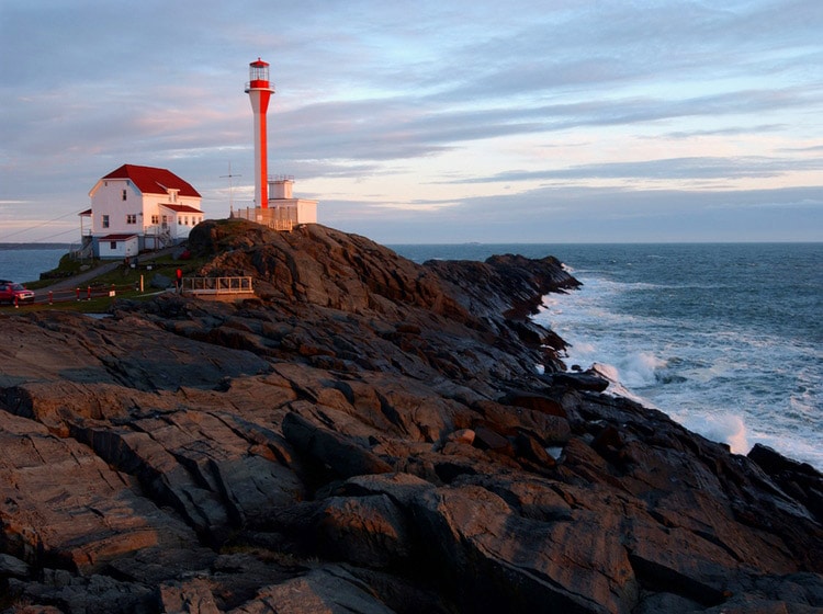 Cape Forchu Lighthouse beside big white house near the sea