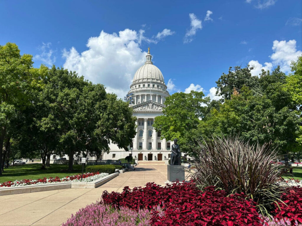 Outside view of the Capitol building in Madison featuring the lush greeneries and flowers