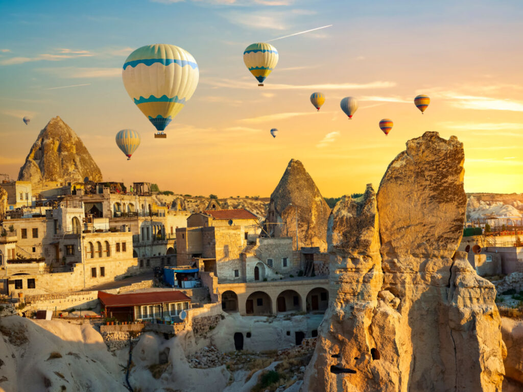 Hot air balloons flying over Cappadocia at sunrise