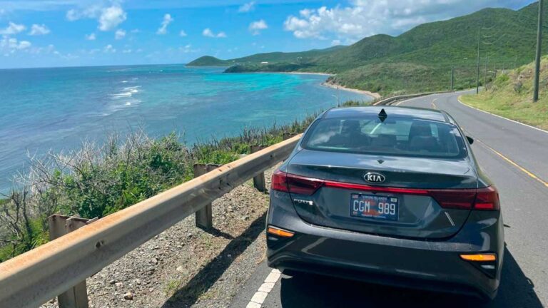 Car in a coastal road with a view of the beach in St. Croix
