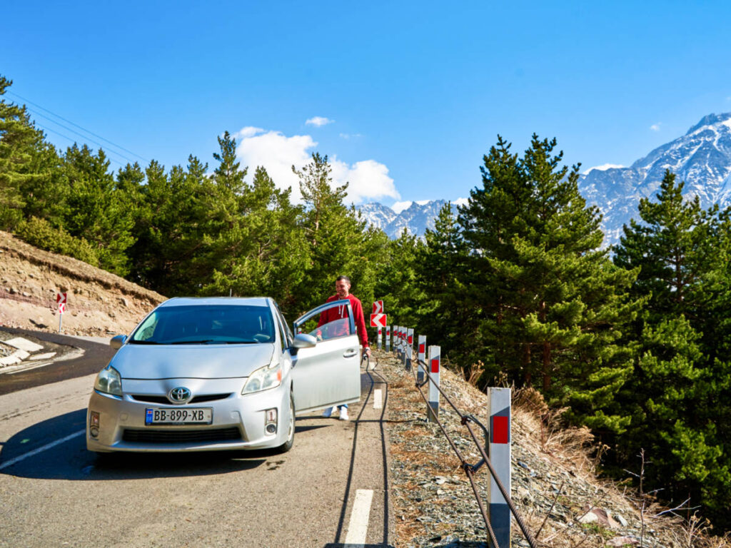 A man beside the car on the mountain