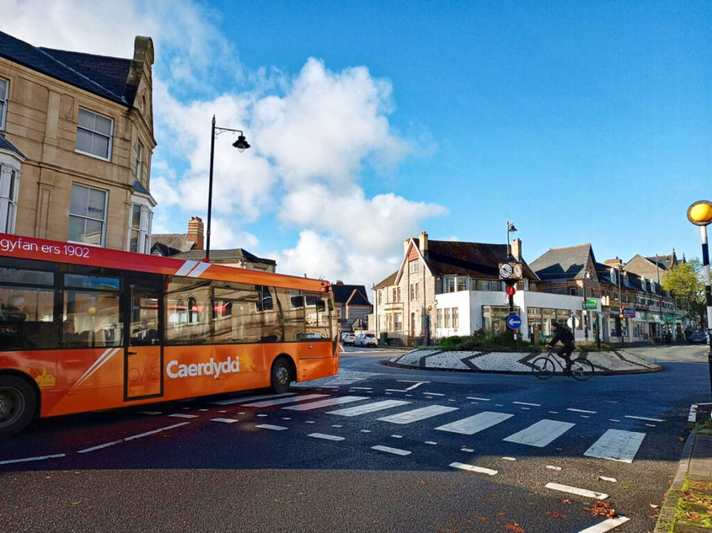 An orange bus driving around Cardiff