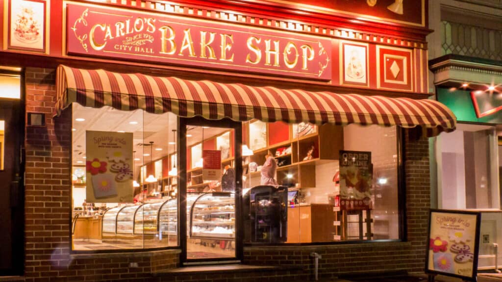 The Carlo’s Bake Shop from the outside with lights at night