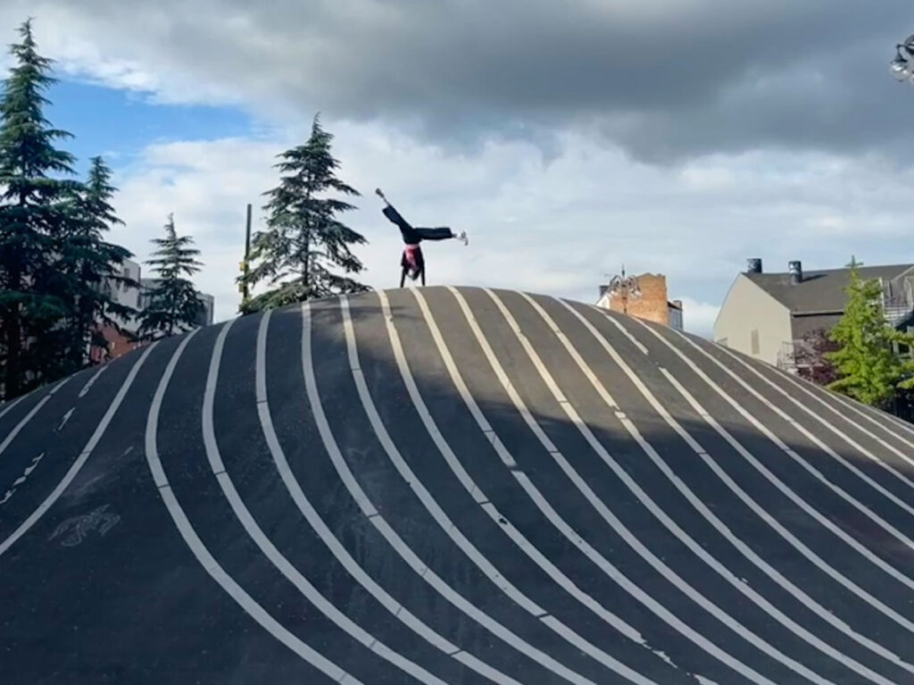 Author Lea Rose cartwheeling at the top of Superkilen Park