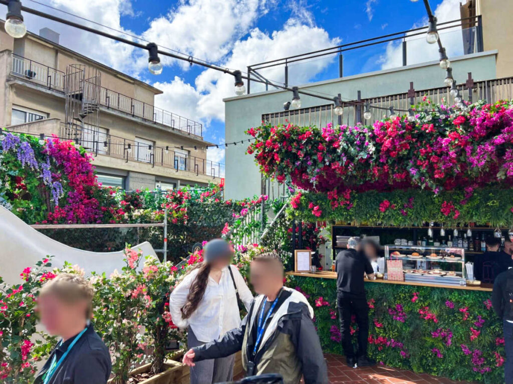 People at the rooftop bar surrounded by flowers on a sunny day