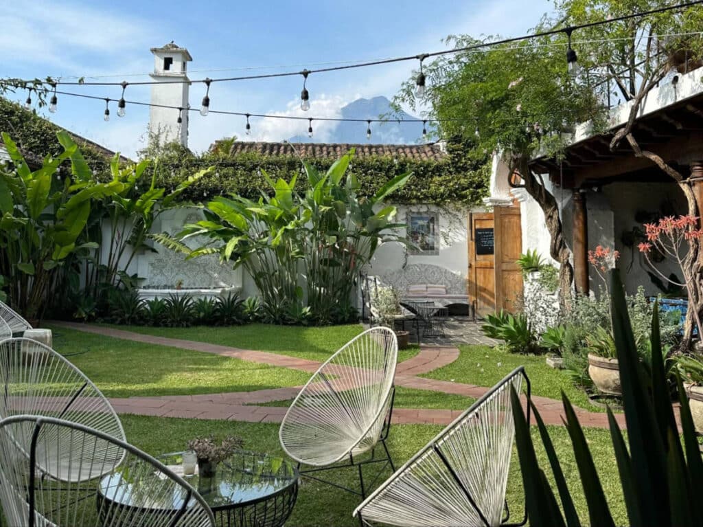 Chairs at table on the courtyard in Casi Casa and the Agua Volcano from afar