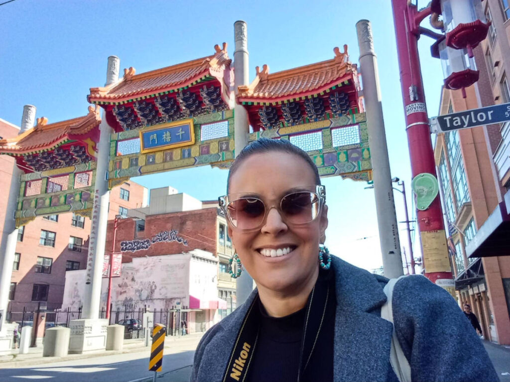 The author Catherine Driver, posing in front of the arch in Chinatown
