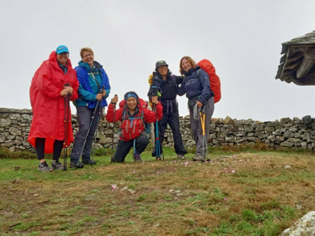 The author Catherine Driver and other hikers in front of the walls and a little church of an old hospital