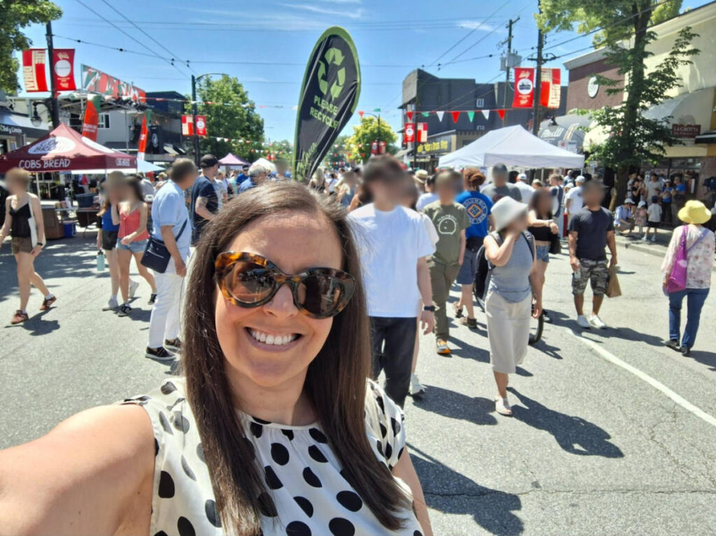 The author Catherine Driver smiling for a photo with the crowd at the Italian Day on Commercial Drive