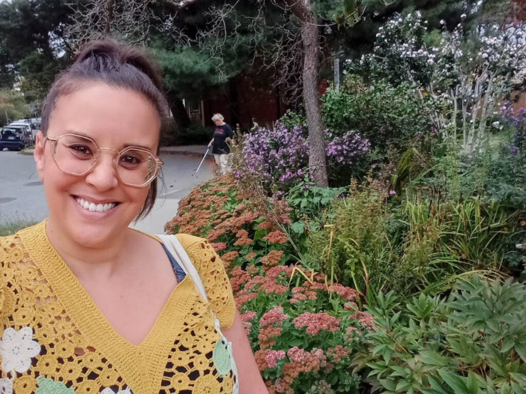 The author Catherine Driver smiling for a selfie on a public garden