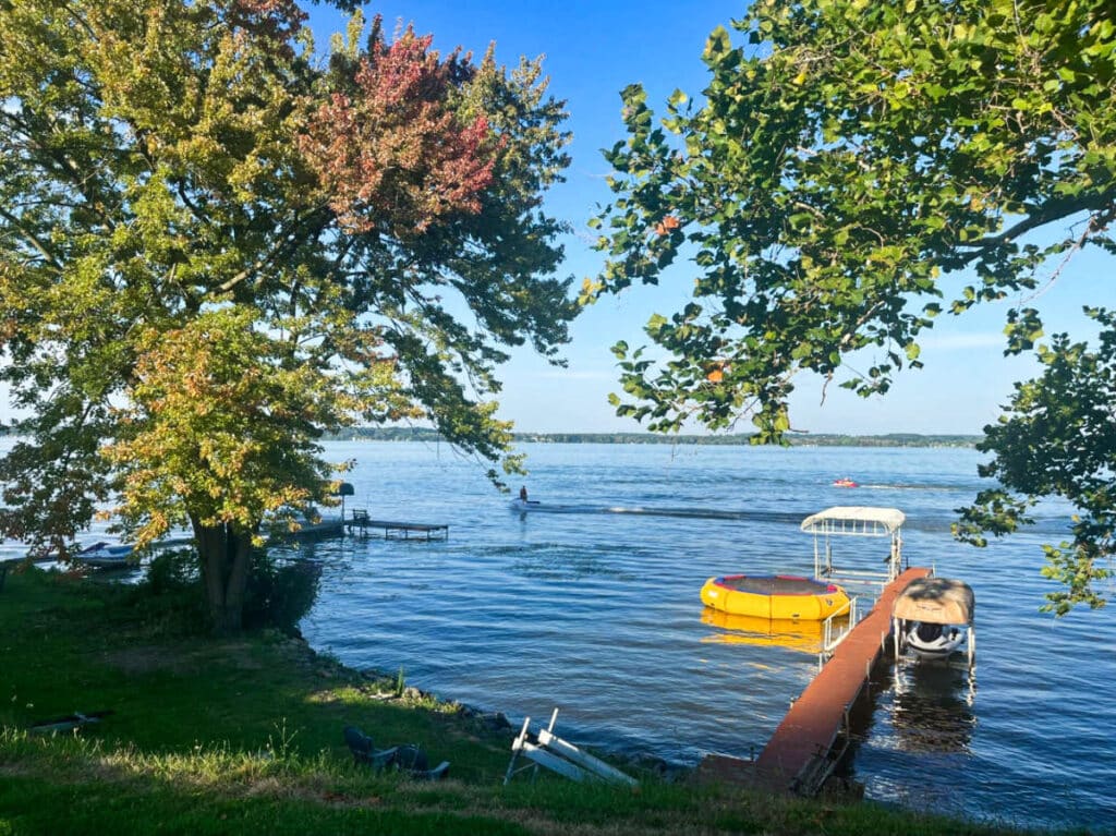 A small boardwalk leading to Cayuga Lake that is surrounded by greenery