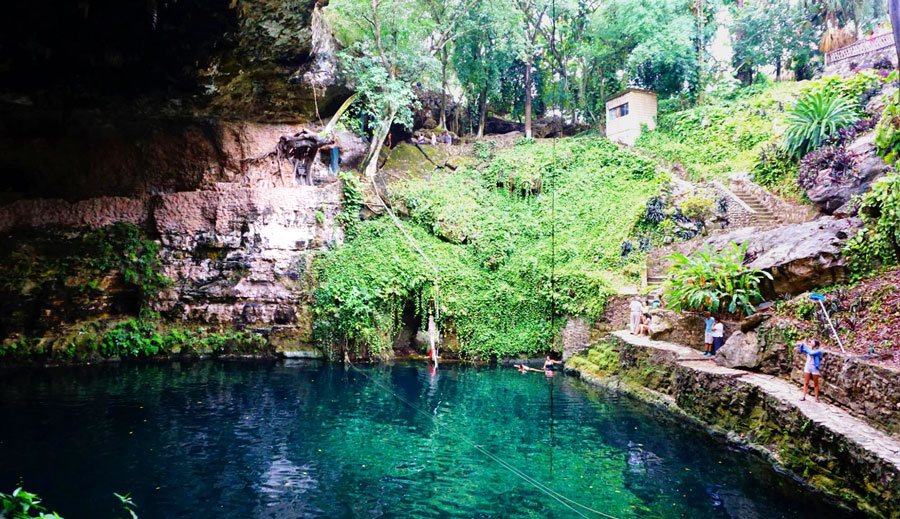 View of the blueish water from Cenote Zaci