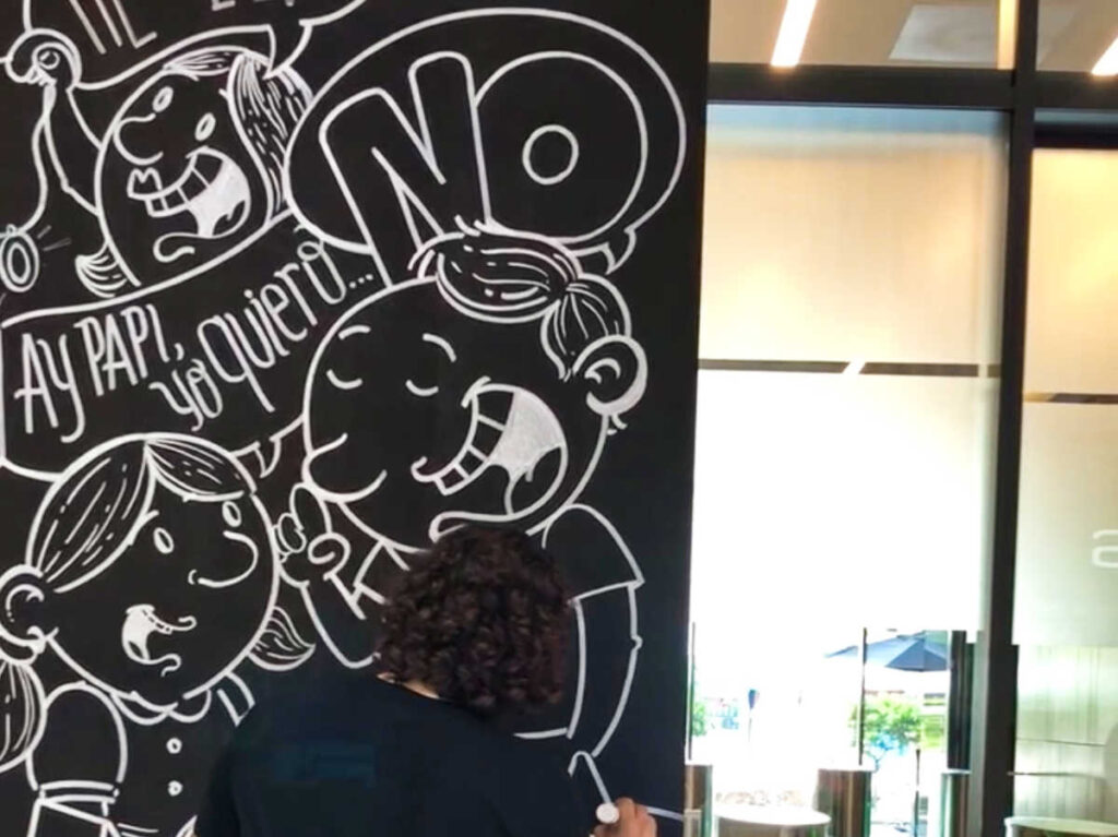 A woman drawing a graphic art with a chalk