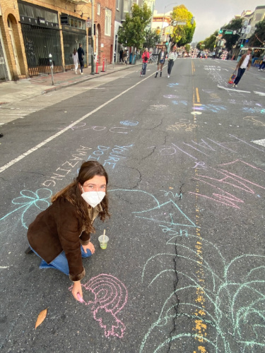 The author, Laura McFarland drawing with a chalk at Valencia Street
