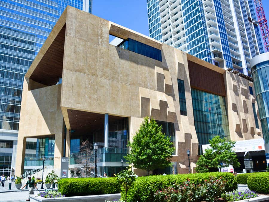 Exterior view of the Uptown Mint Museum with the huge buildings in the background