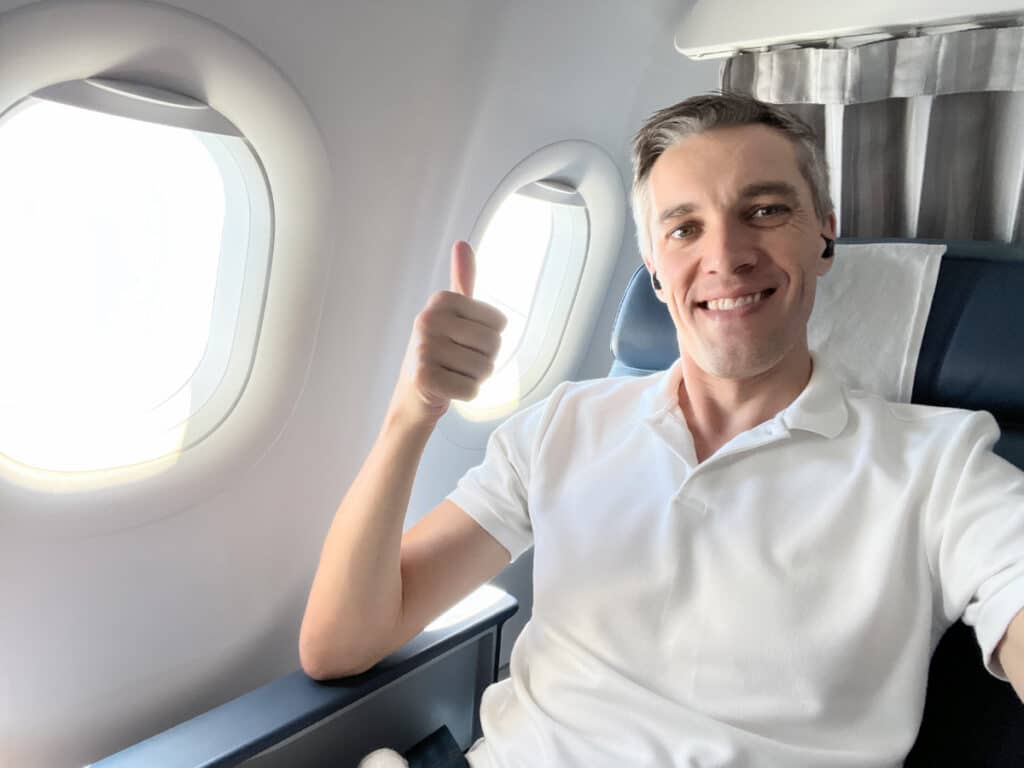 The author Nate Hake in an airplane showing a stamp of approval
