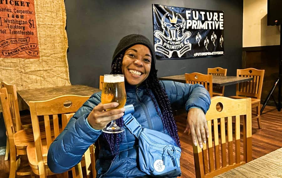 The author Chelsea Booker holding a glass of beer
