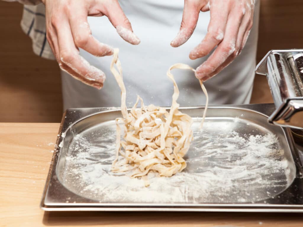 View of the chef's hands preparing the traditional fettuccine noodles