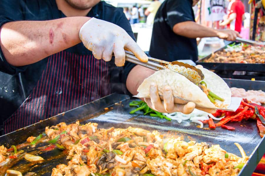 A chef's hands serving tacos on the festival
