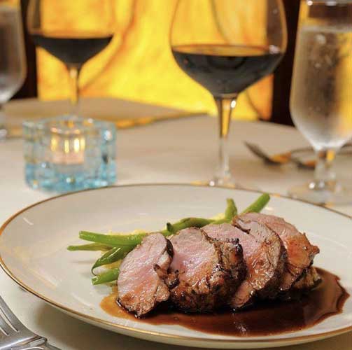A steak on a plate and a glass of wine in Chef’s Table
