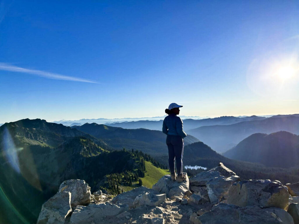 The author Chelsea Booker, admiring the overlooking view from Dege Peak